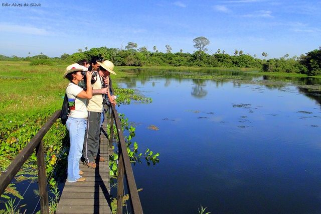 Grupo de turistas na ponte da Fazenda San Francisco, com um lago ao fundo, localizada no Pantanal